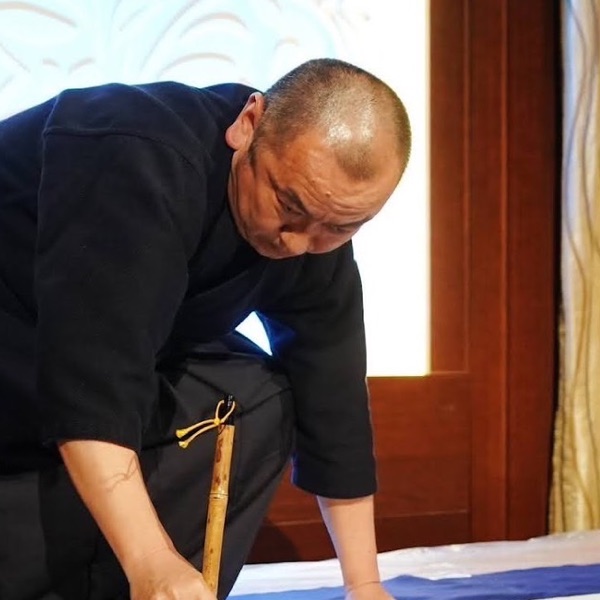 大きな筆で書く藤井翔夢さん